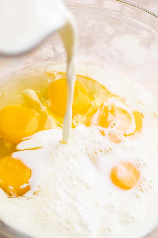 pouring milk over cracked eggs 