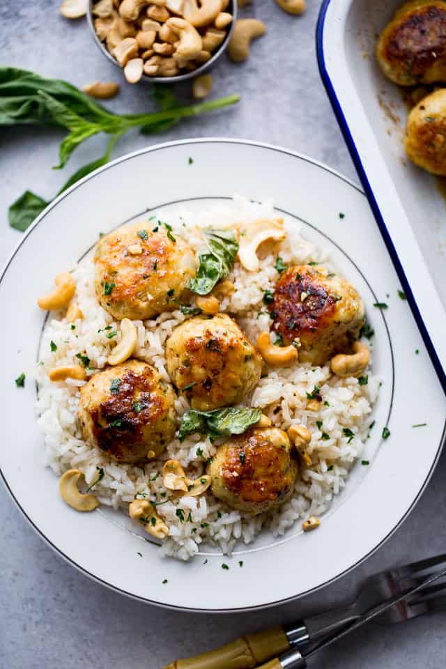 Chicken meatballs are served on white rice.