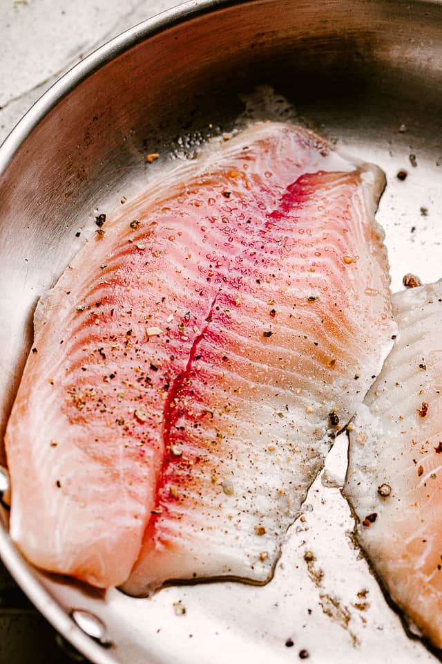 Frying tilapia in a pan, ready to make into fish tacos.