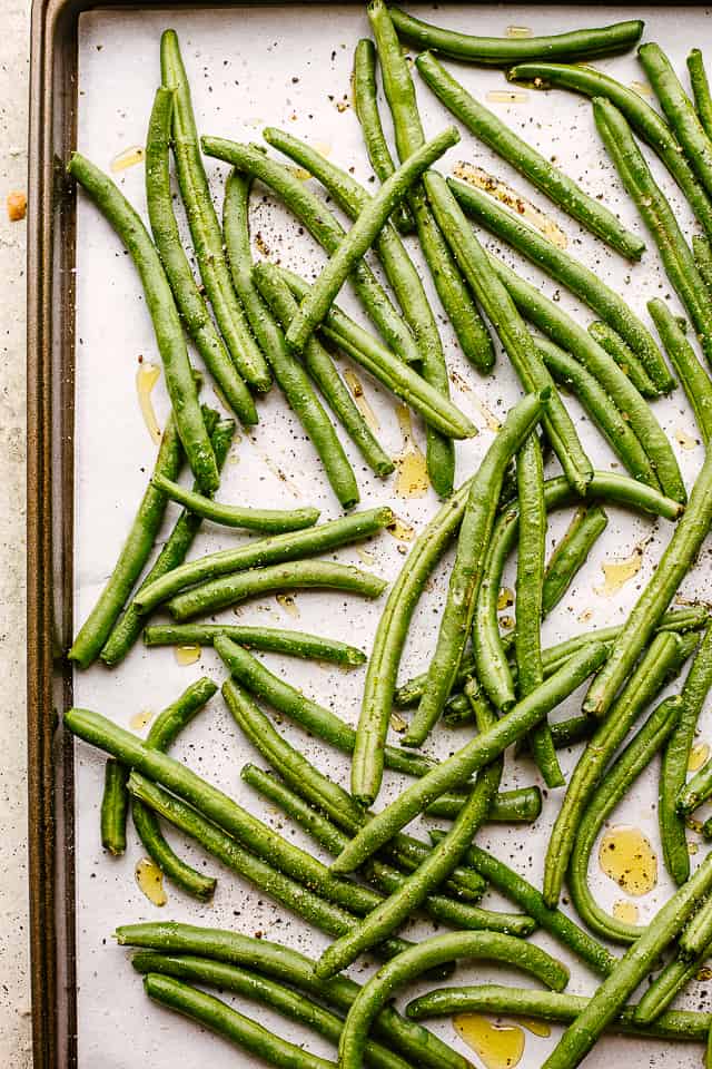 Fresh green beans on a baking sheet.