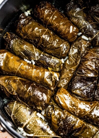 Cooked stuffed grape leaves in a pot.