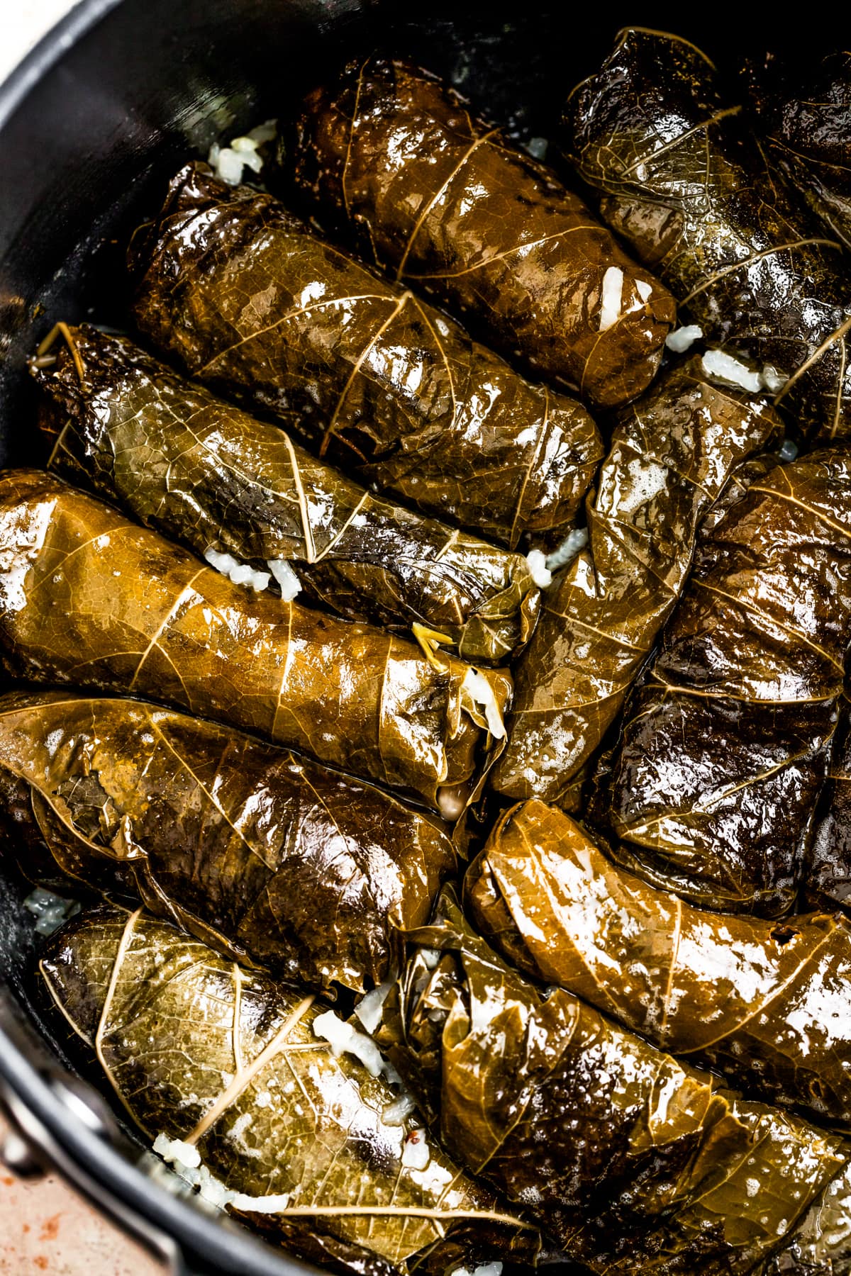 Cooked stuffed grape leaves in a pot.