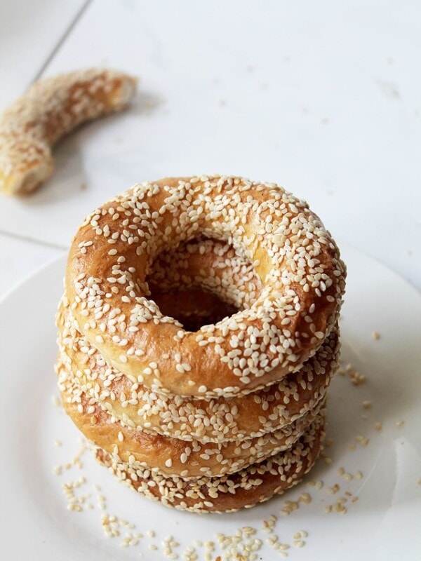 Stack of gevrek, or sesame bagels, on a plate.