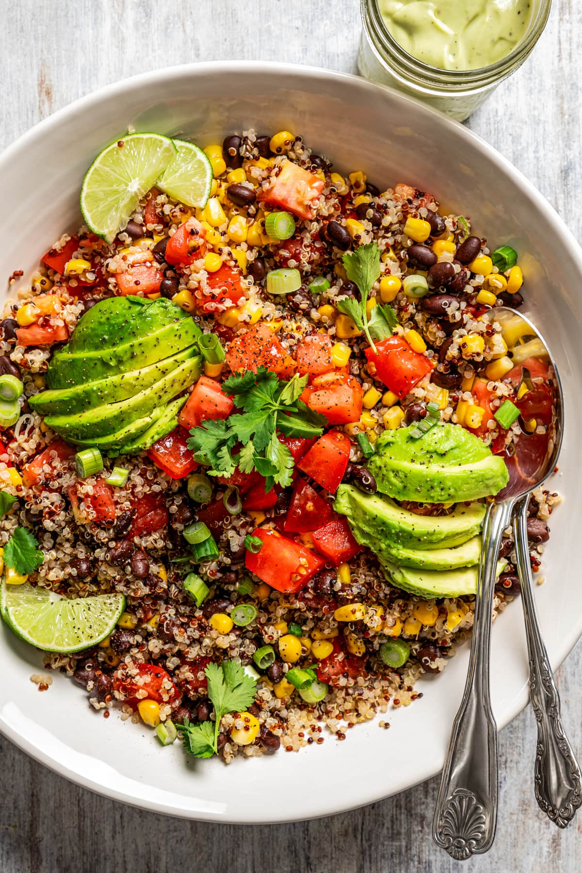 Close-up overhead image of Quinoa Southwestern Salad in a salad bowl tossed with black beans, tomatoes, and corn.