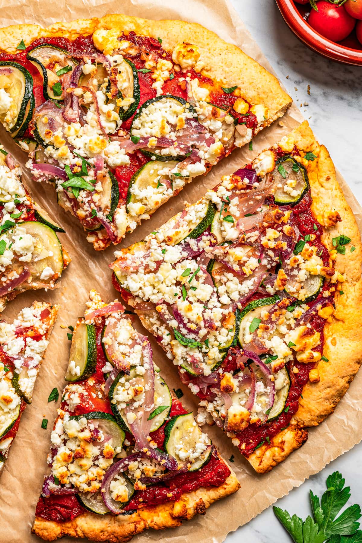 Zucchini goat cheese pizza cut into slices.