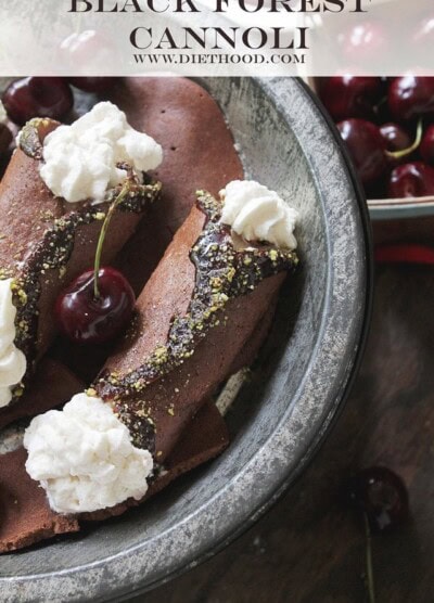 Chocolate cannoli shells are filled with whipped cream in a dark bowl