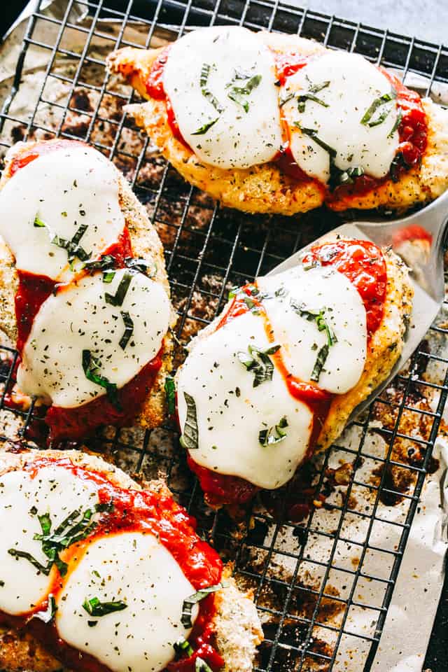 Baked Chicken Parmesan breasts on a cooling rack.