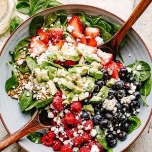 Berries and avocados in a salad bowl topped with feta