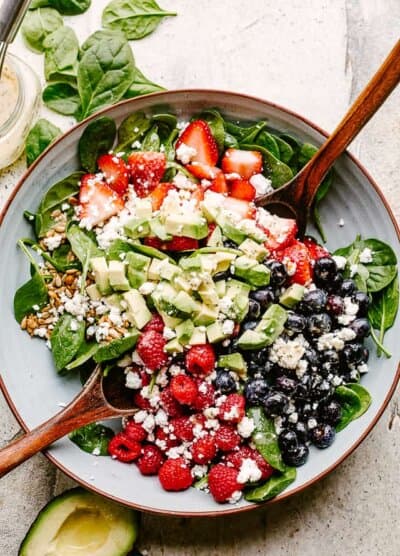 Berries and avocados in a salad bowl topped with feta