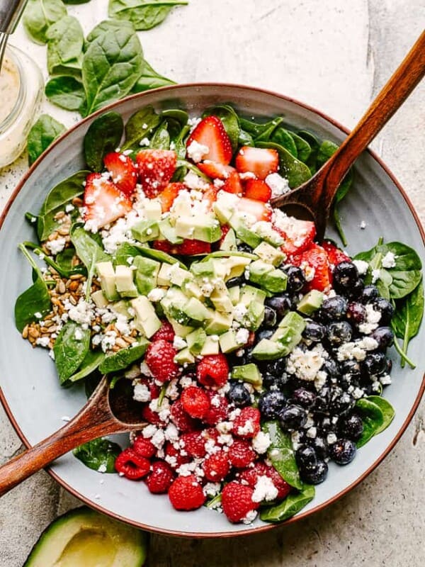Berries and avocados in a salad bowl topped with feta
