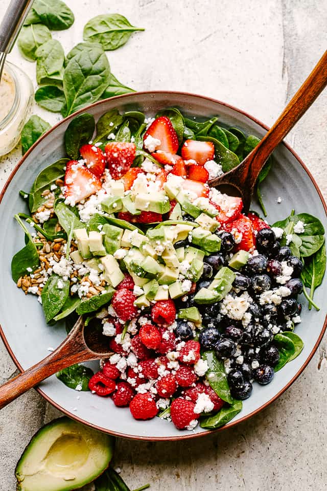 Berries and avocados in a salad bowl topped with feta