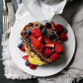 Banana Bread Stuffed French Toast on a plate topped with fresh berries