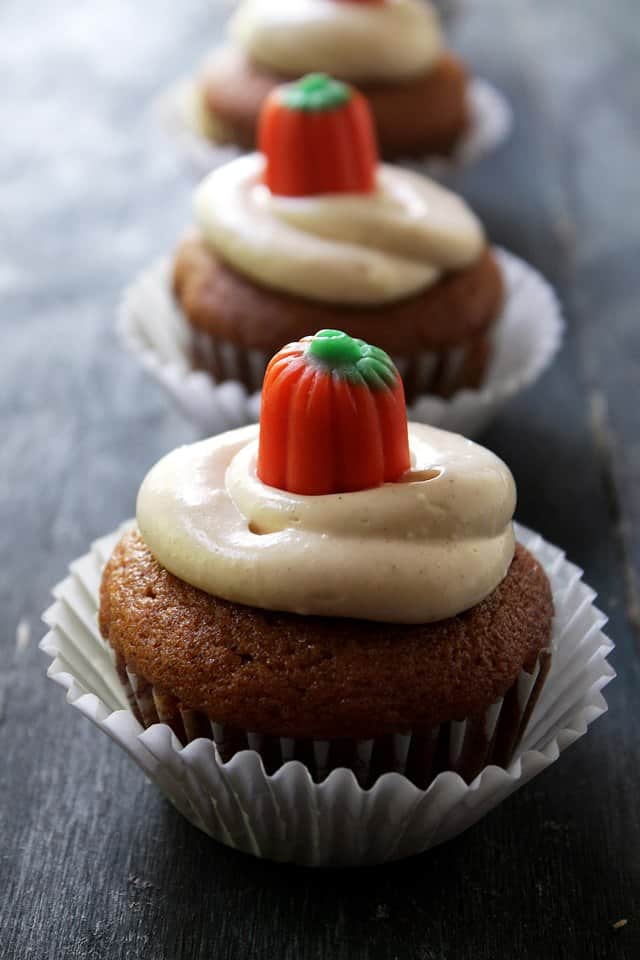 3 pumpkin cupcakes filled and frosted with maple cream cheese frosting.