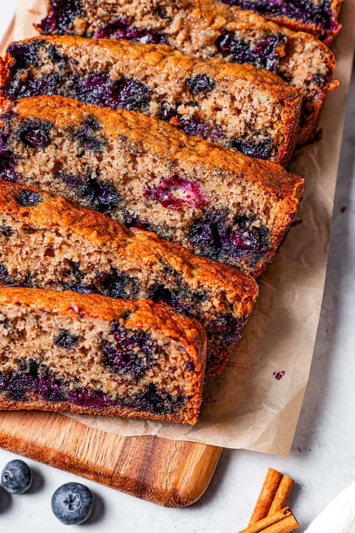 Close-up view of a loaf of blueberry banana bread cut into slices.