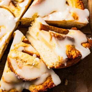 Sliced pear cake arranged on a brown parchment paper.