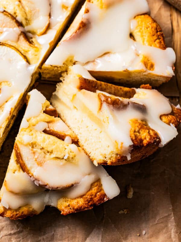 Sliced pear cake arranged on a brown parchment paper.