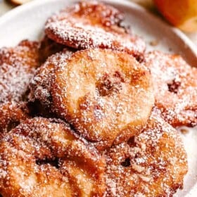 fried apple rings served on a white plate.