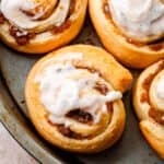 top shot of pumpkin pie cinnamon rolls iced with cream cheese frosting