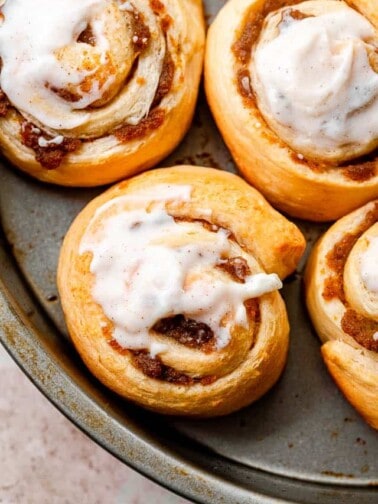 top shot of pumpkin pie cinnamon rolls iced with cream cheese frosting