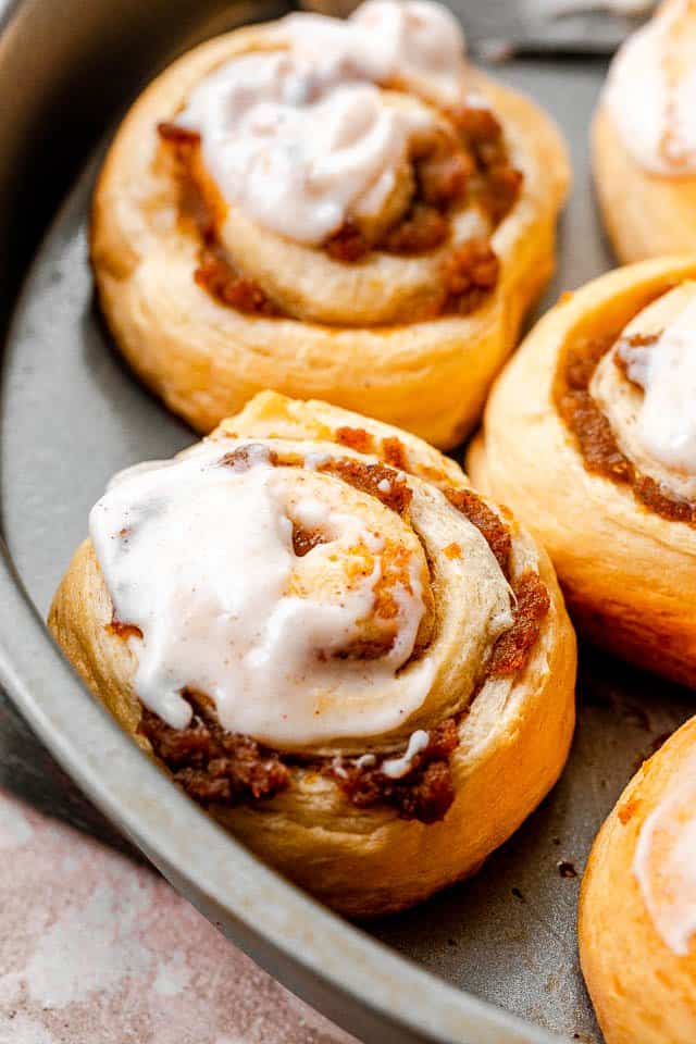 side shot of pumpkin pie cinnamon rolls in a cake pan