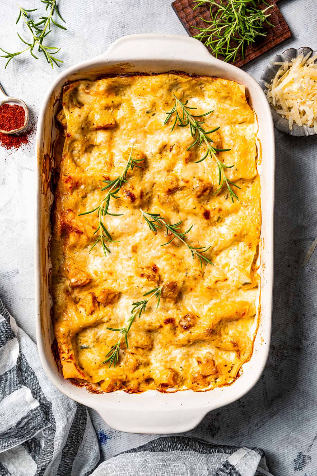 Overhead view of baked butternut squash lasagna in a ceramic casserole dish.