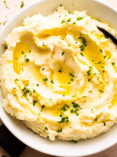 Overhead shot of Garlic Rosemary Mashed Potatoes in a white bowl.