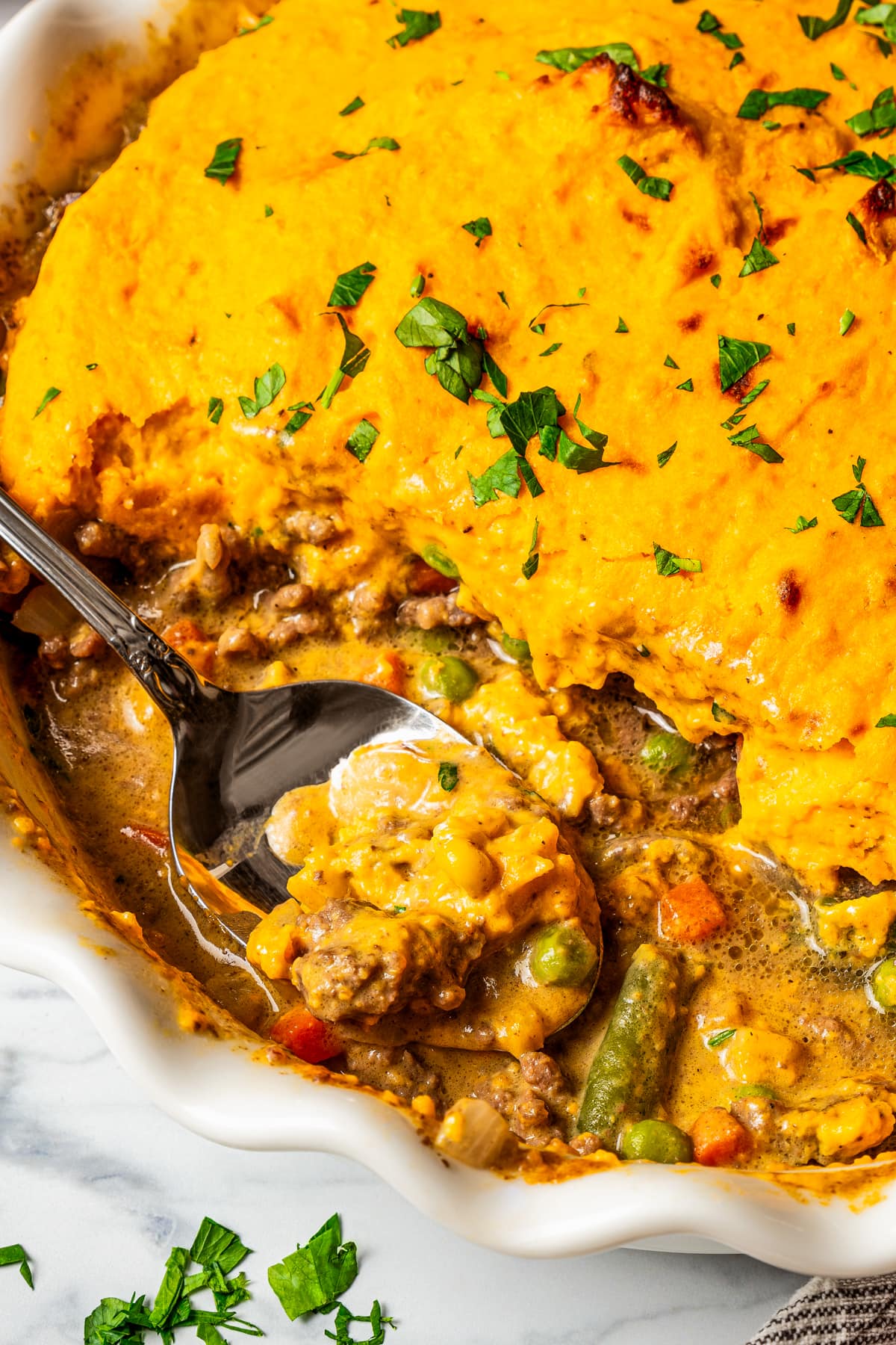 A spoon digging into a Shepherd's pie.