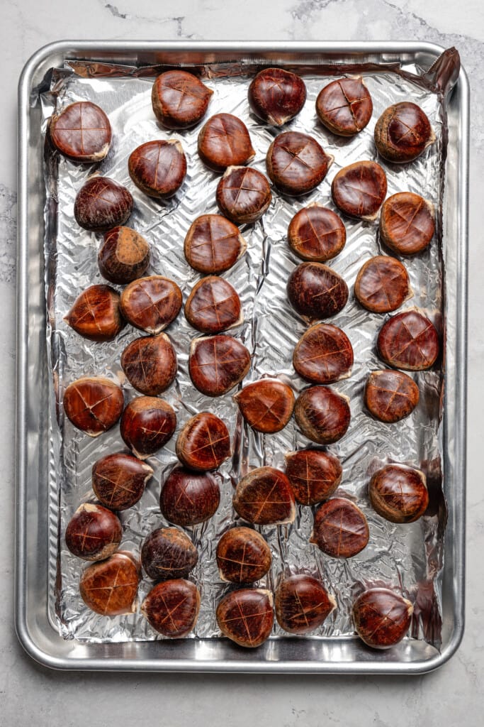 Fresh chestnuts on a pan, ready to roast.