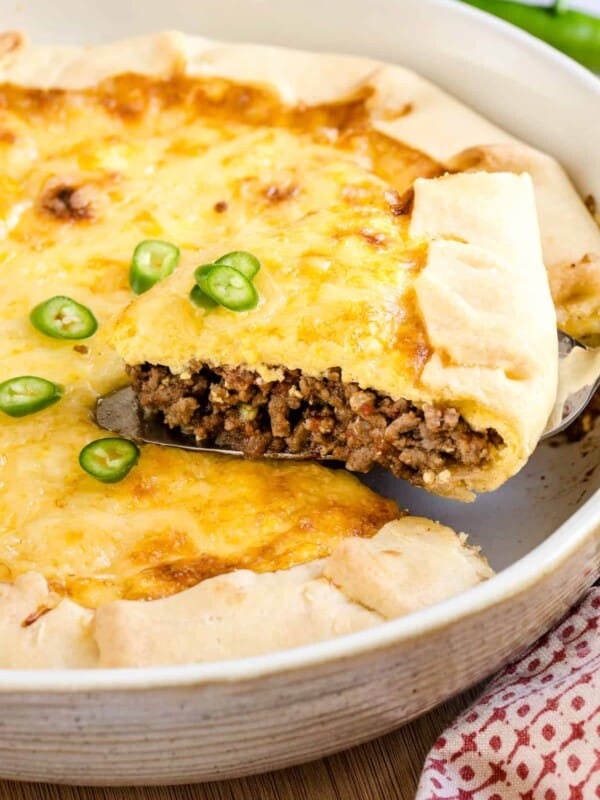 A slice of Tex-Mex cheesy quiche is served from a baking dish.