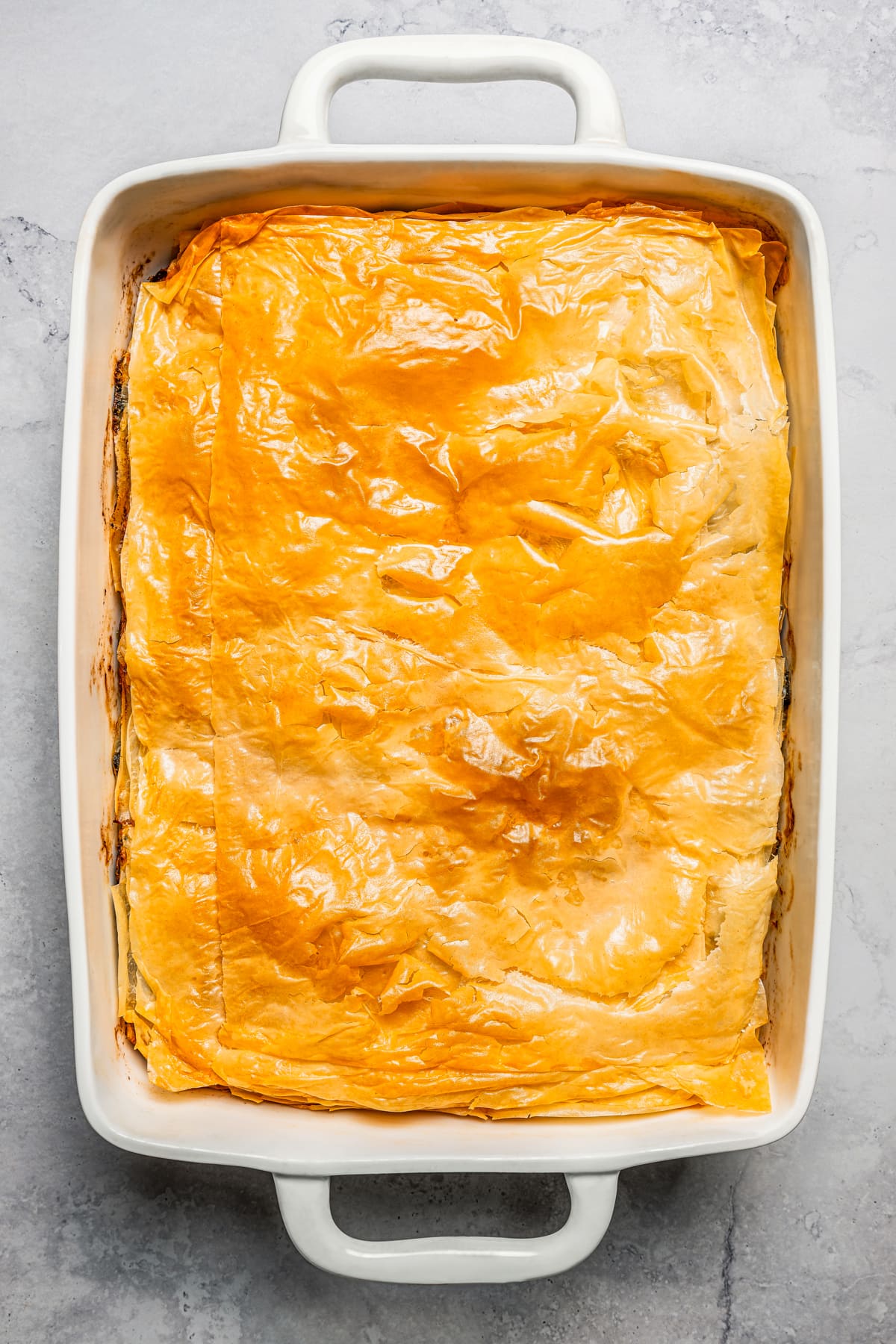 Baked butternut squash and spinach pie in a baking dish.