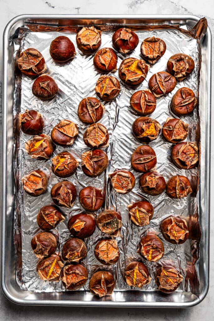 Roasted chestnuts on a baking sheet.