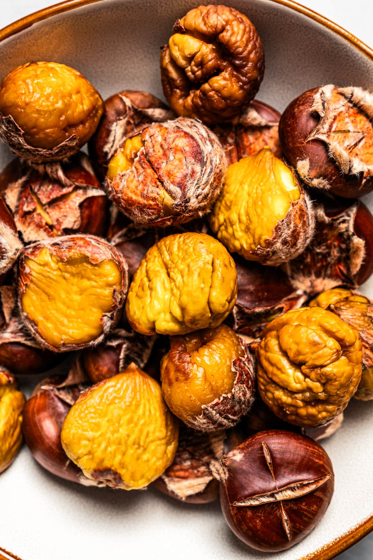 Close-up photo of roasted chestnuts served in a bowl.