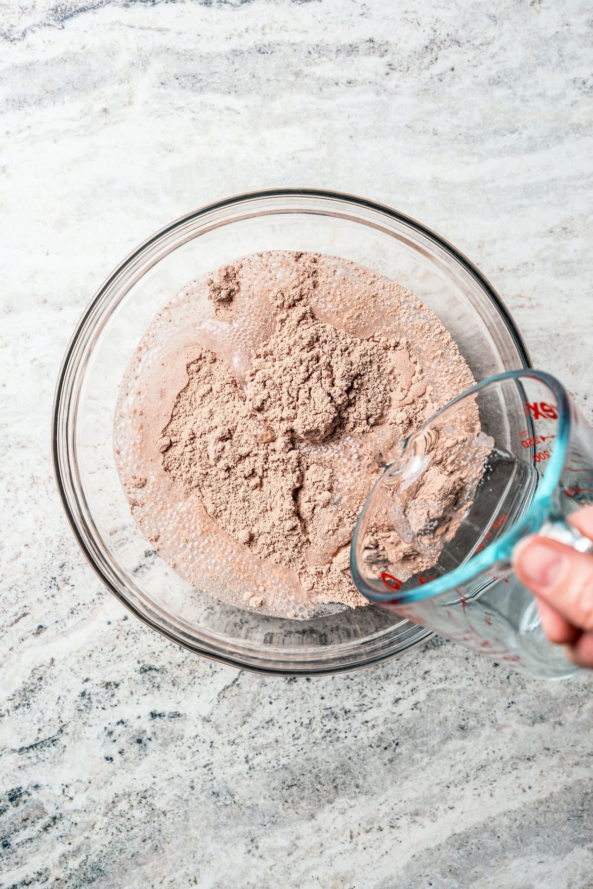 These delicious, moist, fudgy 2-ingredient brownies are made with only a boxed brownie mix and Sprite. That's it! The easiest dessert ever. Sprite being poured from a measuring cup into dry cake mix in a bowl.