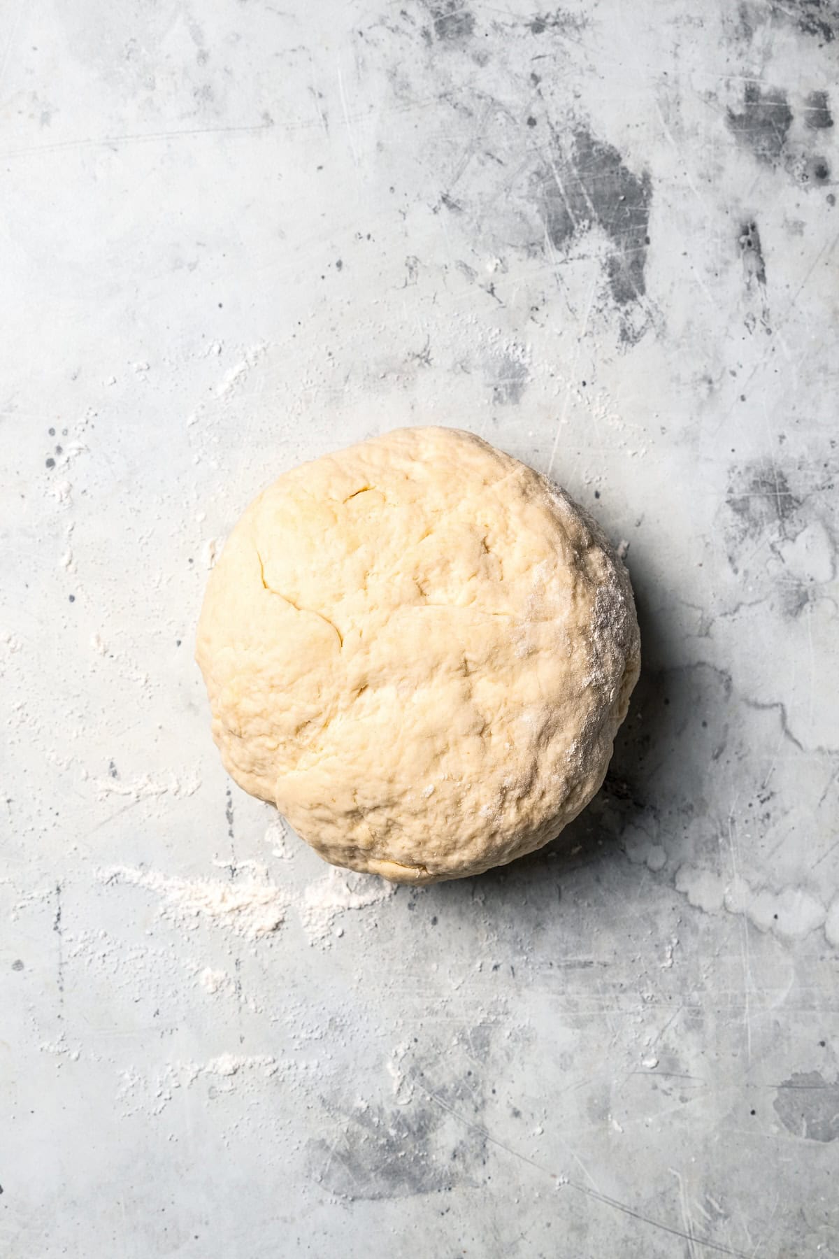 These sweet and gooey homemade caramel rolls require no yeast, rise time, or kneading. They're easy, quick, and best of all, delicious! A ball of caramel roll dough on a countertop.