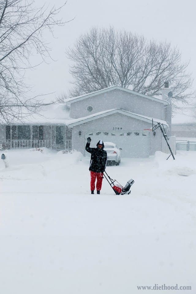 A man with a snowblower in the snow
