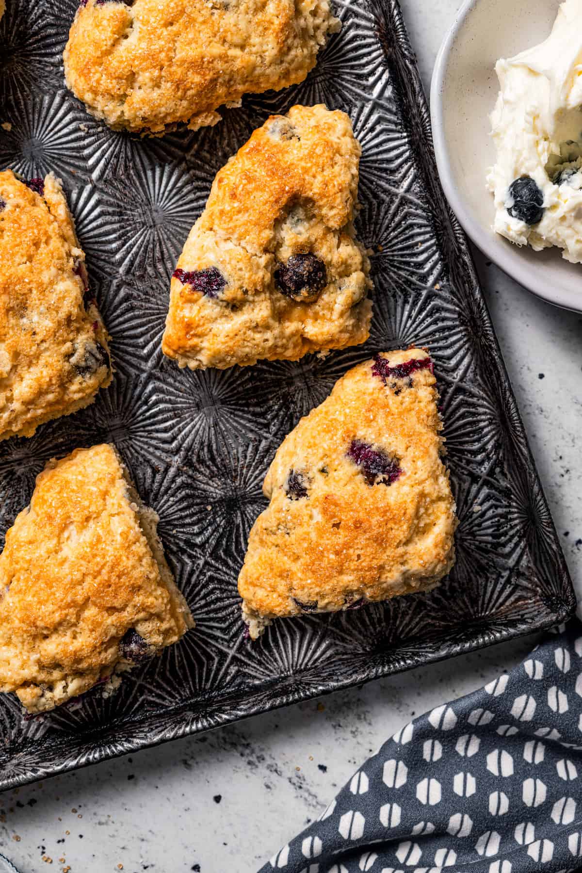 Overhead view of blueberry scones on a baking sheet.