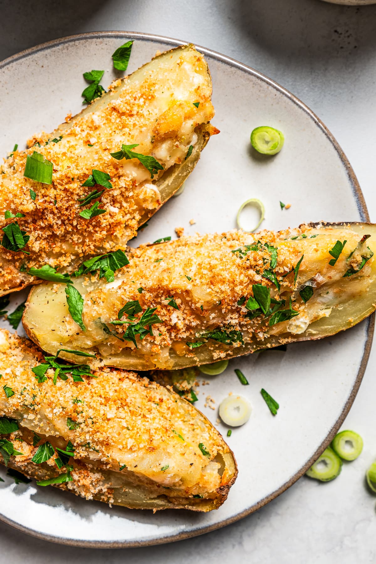 Overhead view of three crispy potato skins on a plate.