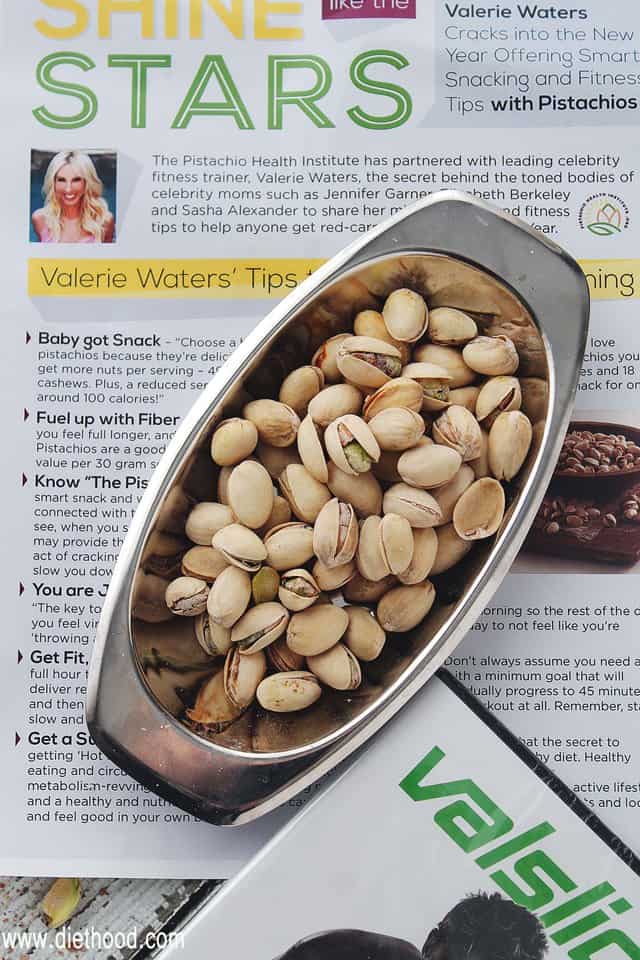 A bowl of pistachios on top of an article about pistachios 