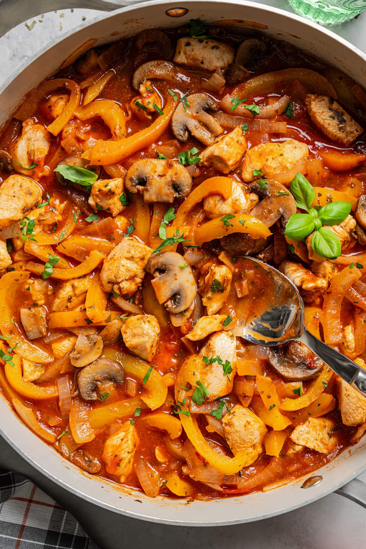 Saucy chicken with mushrooms, onions, and bell peppers in the pan.