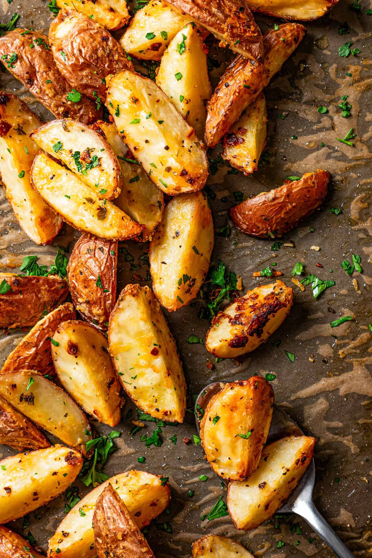 Roasted potato wedges on a dark backdrop.