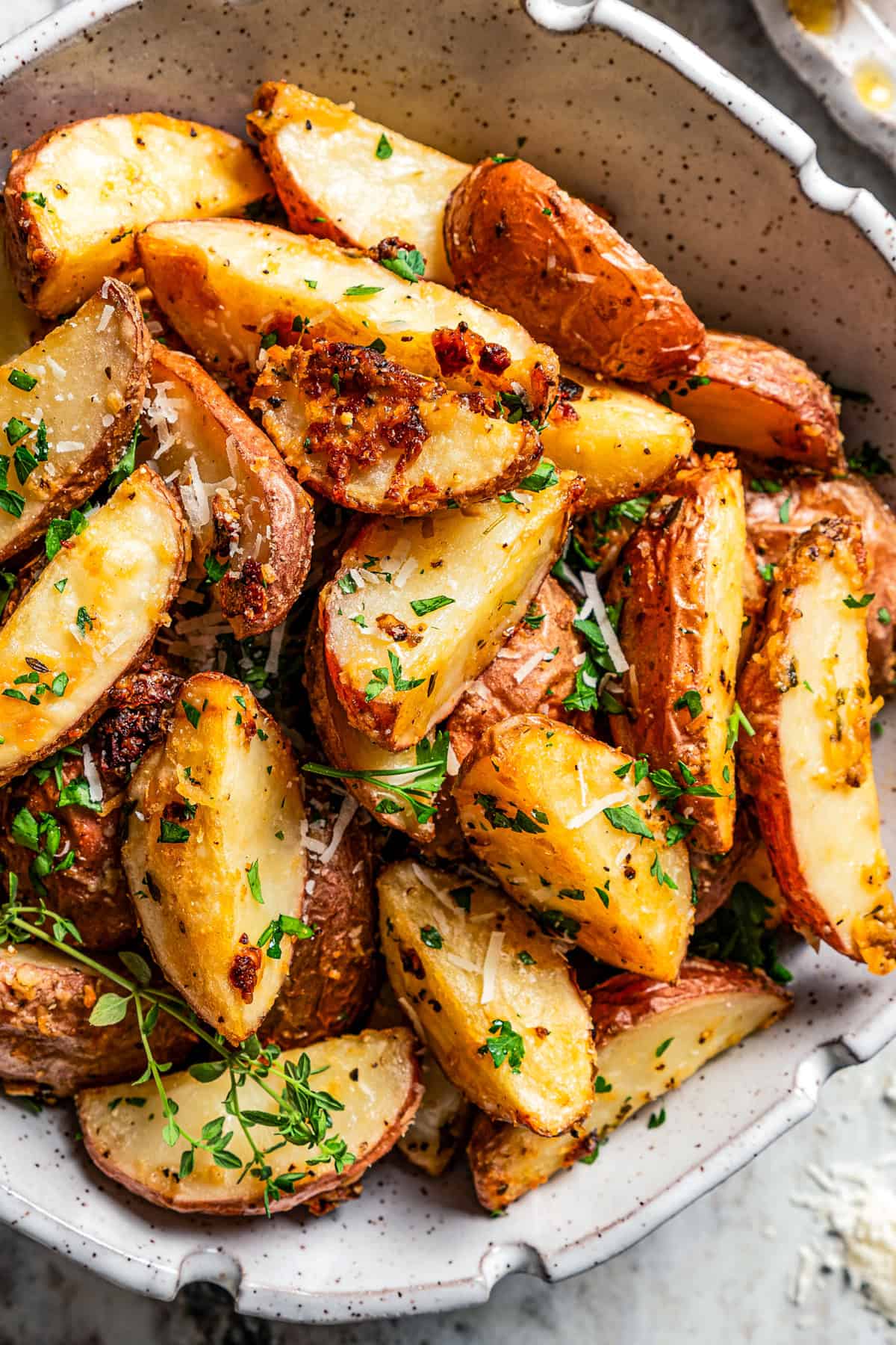 Parmesan potato wedges served in a bowl.