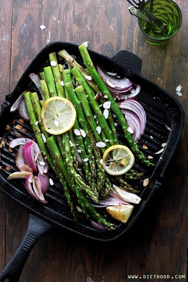 Asparagus with almond slices, red onion, and lemon slices.