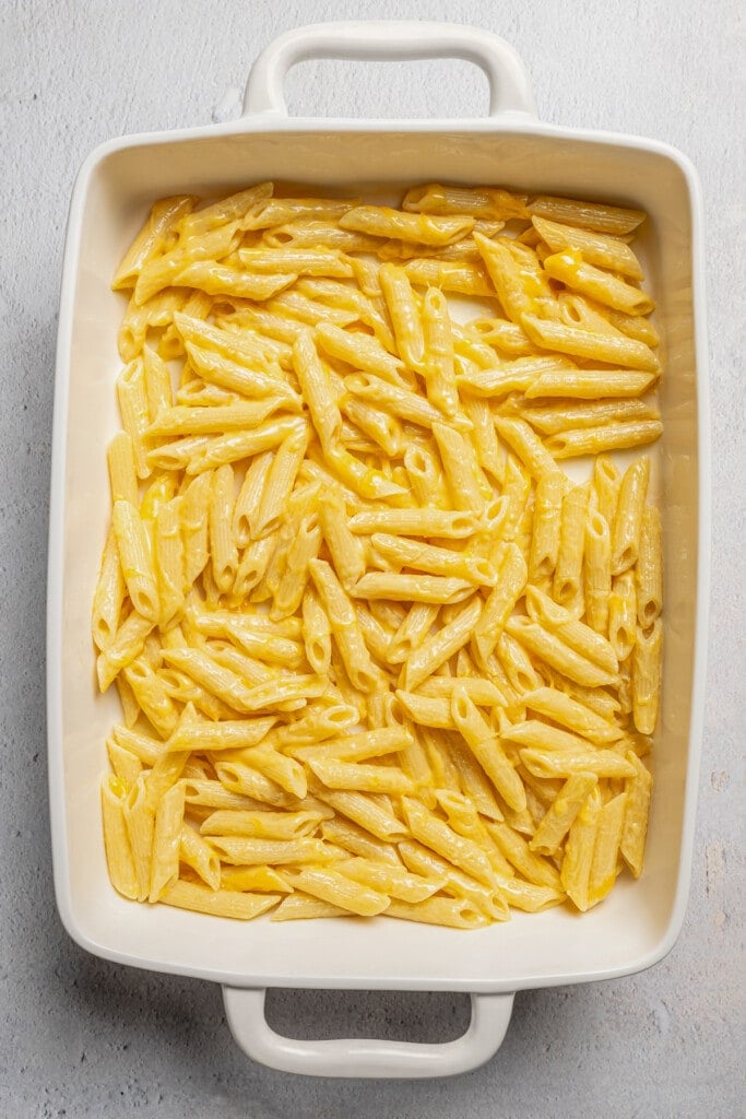 Cheesy penne pasta in a casserole dish.
