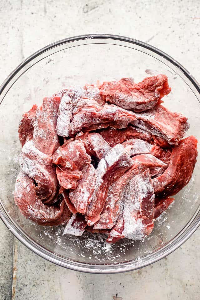 raw steak slices dusted with corn starch.