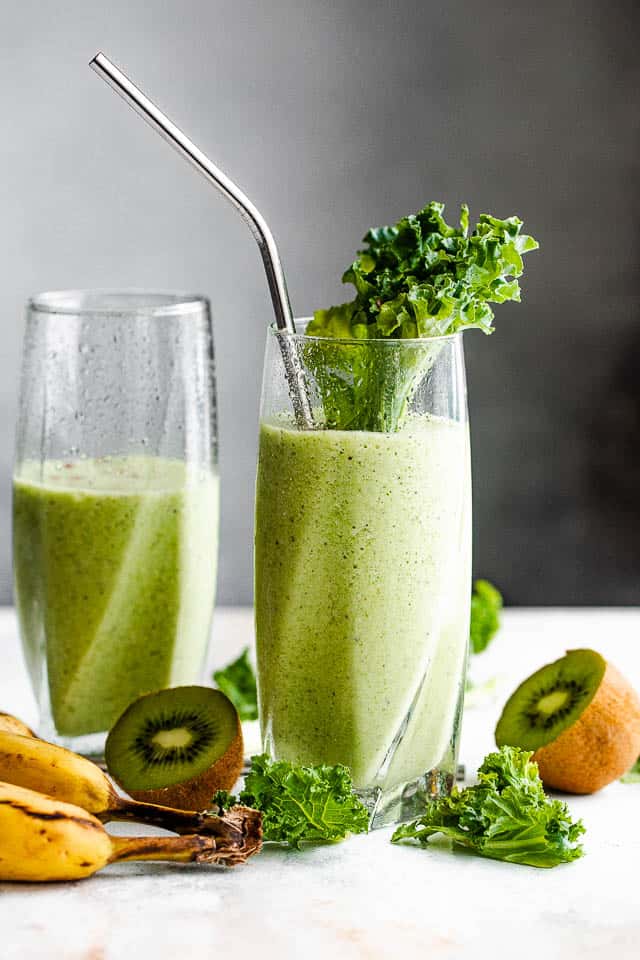 two tall drinking glasses with green smoothie