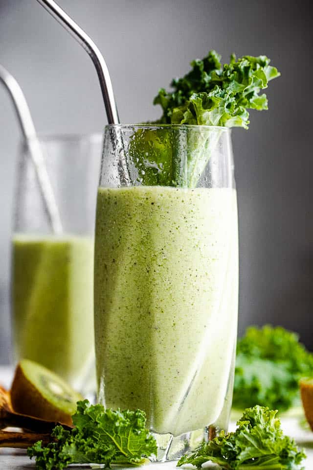 Close-up shot of a tall glass filled with a kale smoothie.