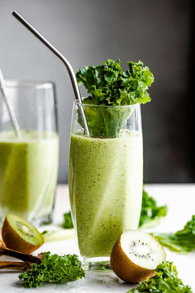 two tall drinking glasses with green smoothie