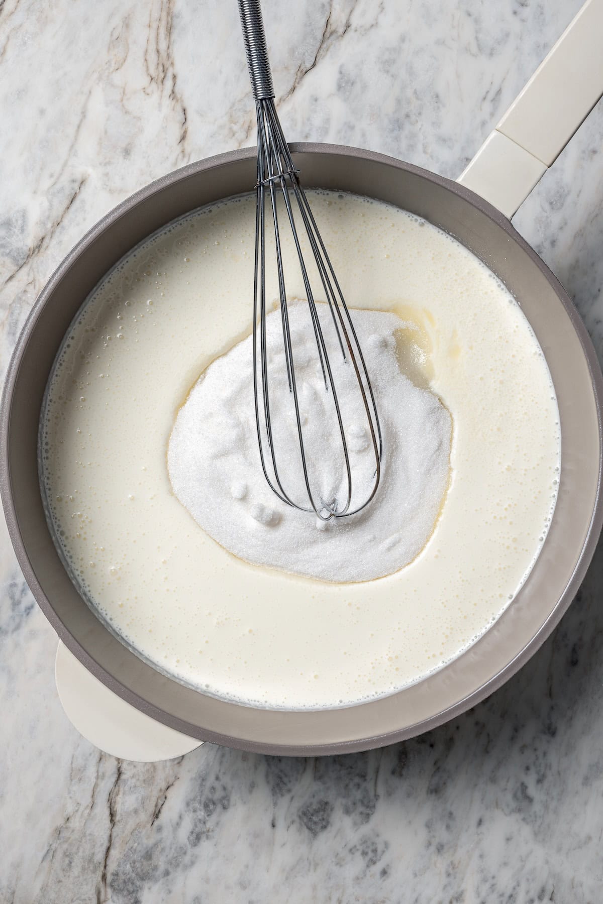 This chocolate chip cookie dough ice cream combines creamy homemade vanilla ice cream with irresistible chunks of buttery cookie dough. Milk, heavy cream, and sugar being whisked together in a saucepan.