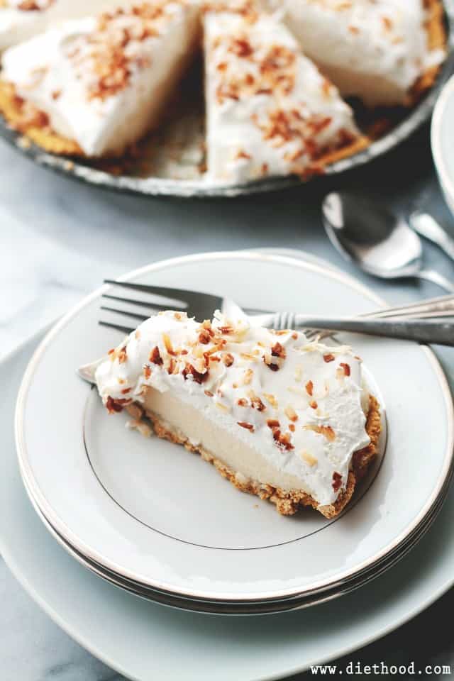 A big slice of banana cream pie with the rest of the pie in the background.