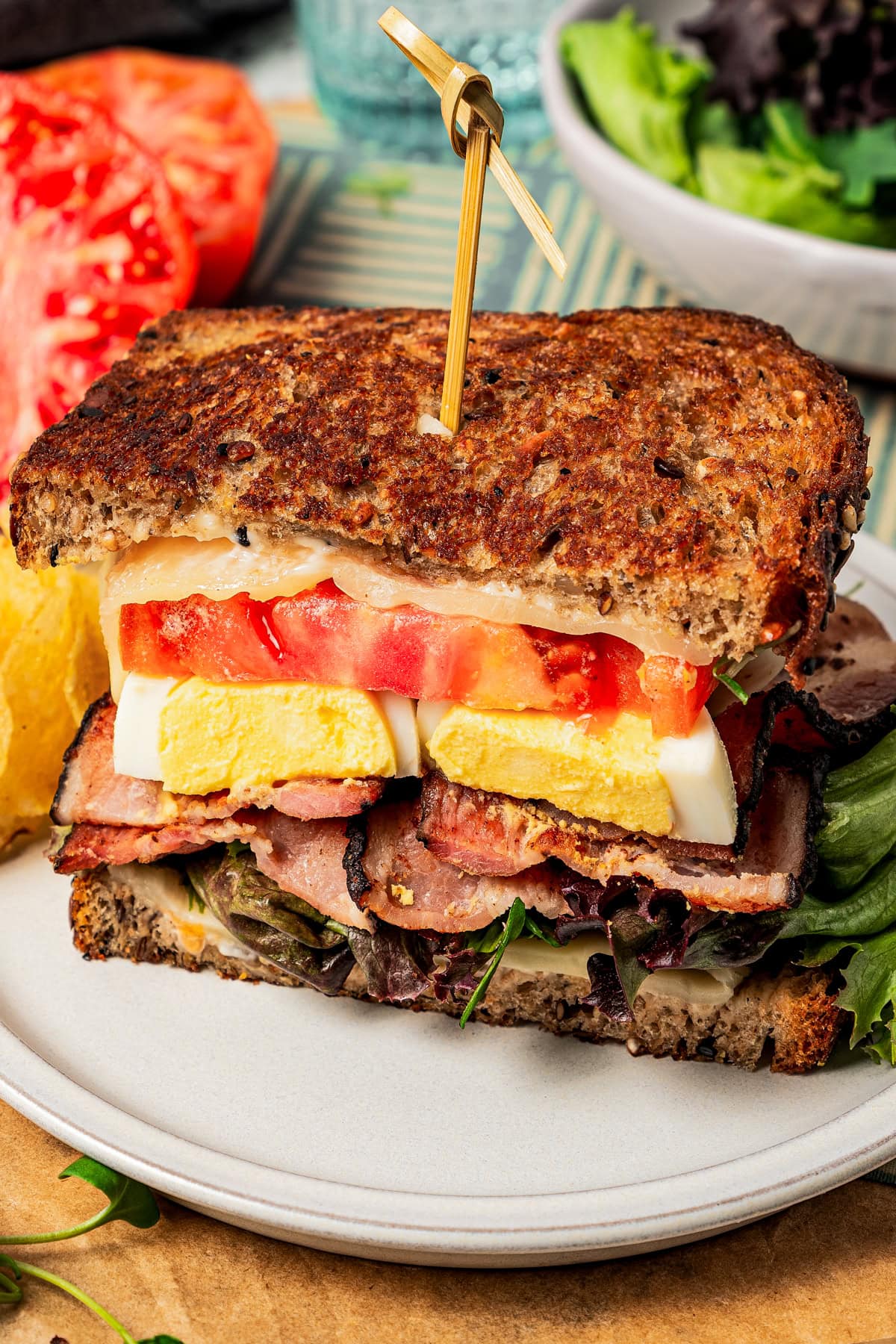 Sandwich with eggs, tomatoes, bacon, and cheese.